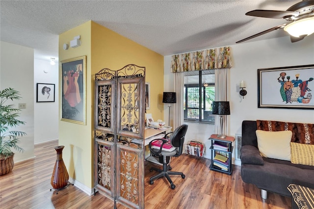 office space featuring a textured ceiling, lofted ceiling, a ceiling fan, and wood finished floors