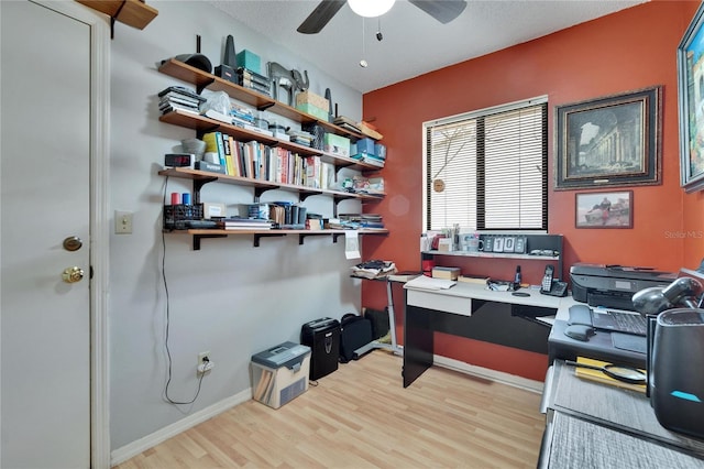 home office with a ceiling fan, baseboards, and light wood finished floors