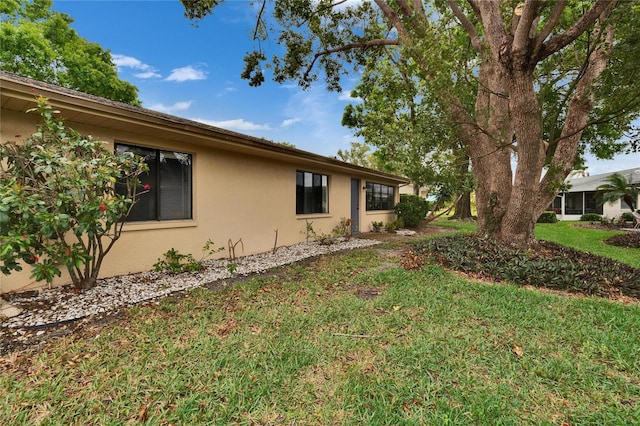 exterior space featuring stucco siding and a yard