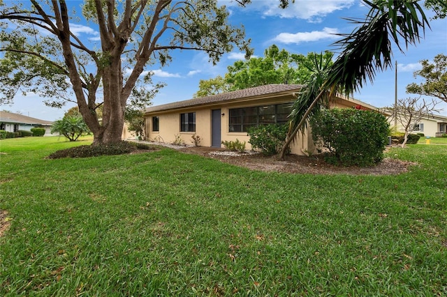 single story home featuring a front lawn and stucco siding