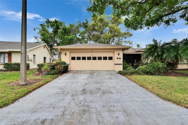 view of front of home with a front yard, an attached garage, driveway, and stucco siding