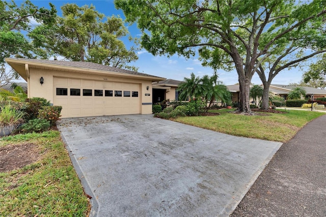 ranch-style home with stucco siding, concrete driveway, a garage, and a front yard