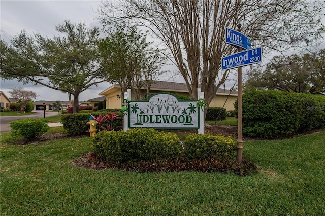 community sign with a garage and a yard