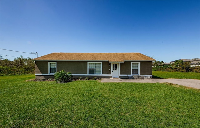 ranch-style home featuring stucco siding and a front lawn