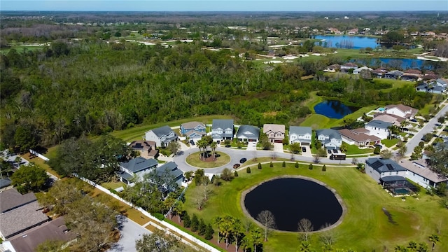 aerial view featuring a residential view, a water view, and a view of trees