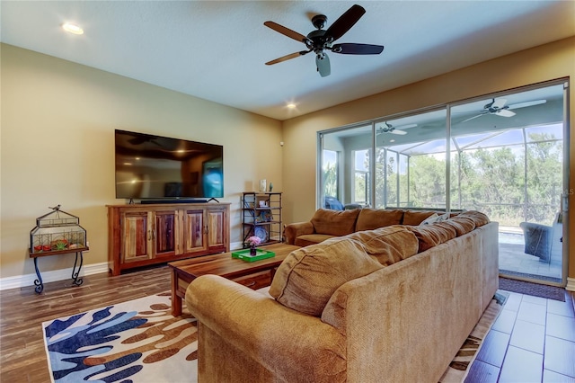 living room with wood finished floors, baseboards, a sunroom, and ceiling fan