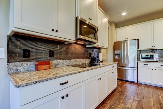 kitchen featuring a toaster, decorative backsplash, white cabinets, stainless steel appliances, and dark wood-style flooring