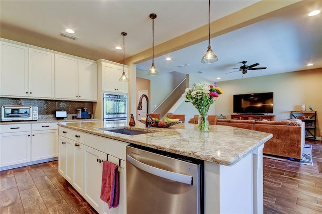 kitchen featuring wood finish floors, tasteful backsplash, appliances with stainless steel finishes, and a sink