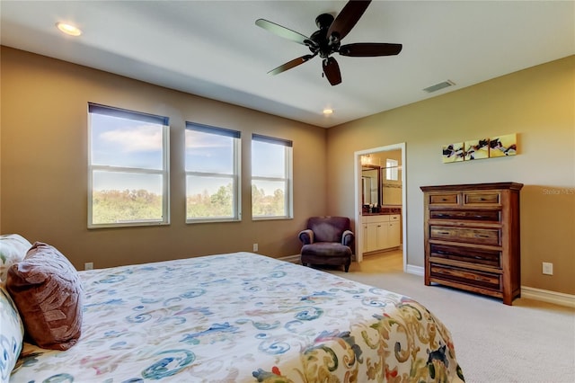 bedroom featuring visible vents, light carpet, a ceiling fan, connected bathroom, and baseboards