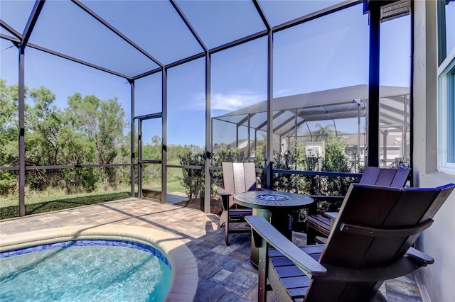 outdoor pool featuring glass enclosure and a patio