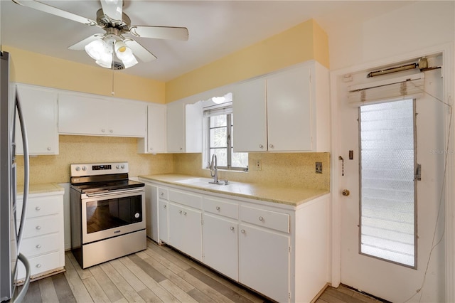 kitchen featuring a sink, light countertops, white cabinets, appliances with stainless steel finishes, and tasteful backsplash