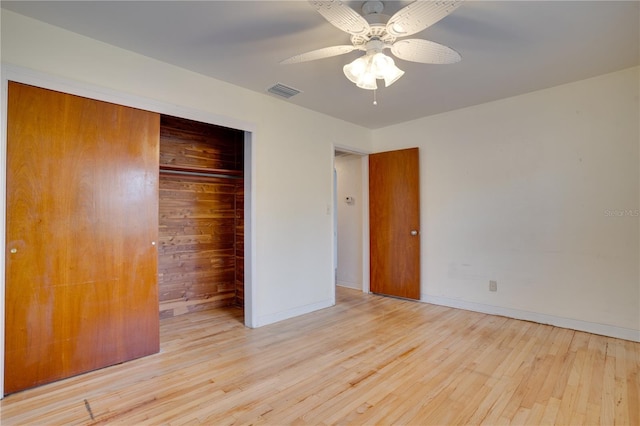 unfurnished bedroom featuring hardwood / wood-style floors, a ceiling fan, baseboards, visible vents, and a closet