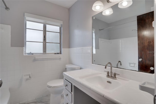 full bathroom featuring toilet, marble finish floor, tile walls, a shower, and vanity