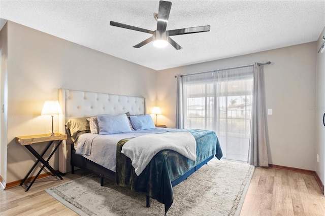 bedroom with baseboards, light wood-style floors, ceiling fan, and a textured ceiling