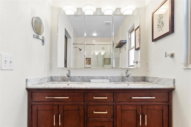 full bath with double vanity, visible vents, a stall shower, and a sink