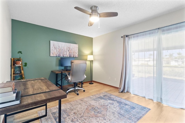 office space with ceiling fan, baseboards, a textured ceiling, and wood finished floors