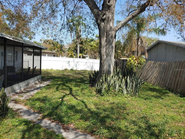 view of yard featuring a fenced backyard and a sunroom