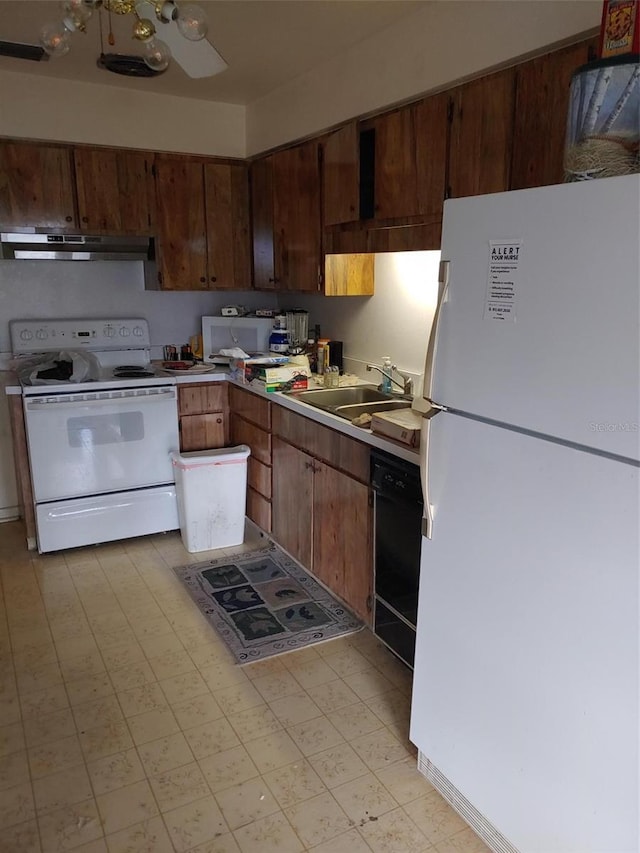 kitchen featuring under cabinet range hood, light floors, light countertops, white appliances, and a sink