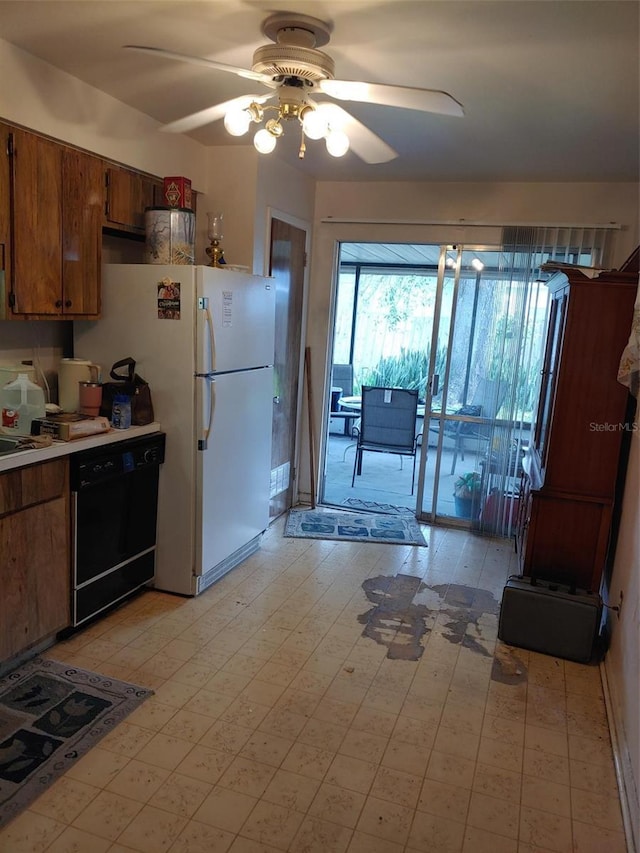 kitchen with brown cabinets, a ceiling fan, freestanding refrigerator, light countertops, and dishwasher