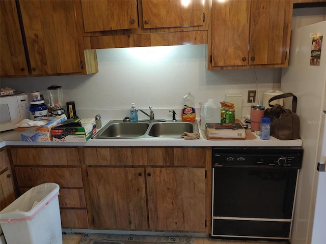 kitchen with brown cabinets, a sink, light countertops, white microwave, and dishwasher