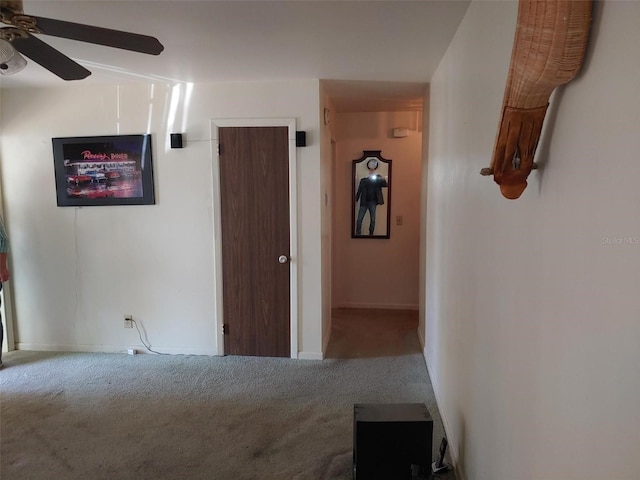 hall featuring carpet and baseboards