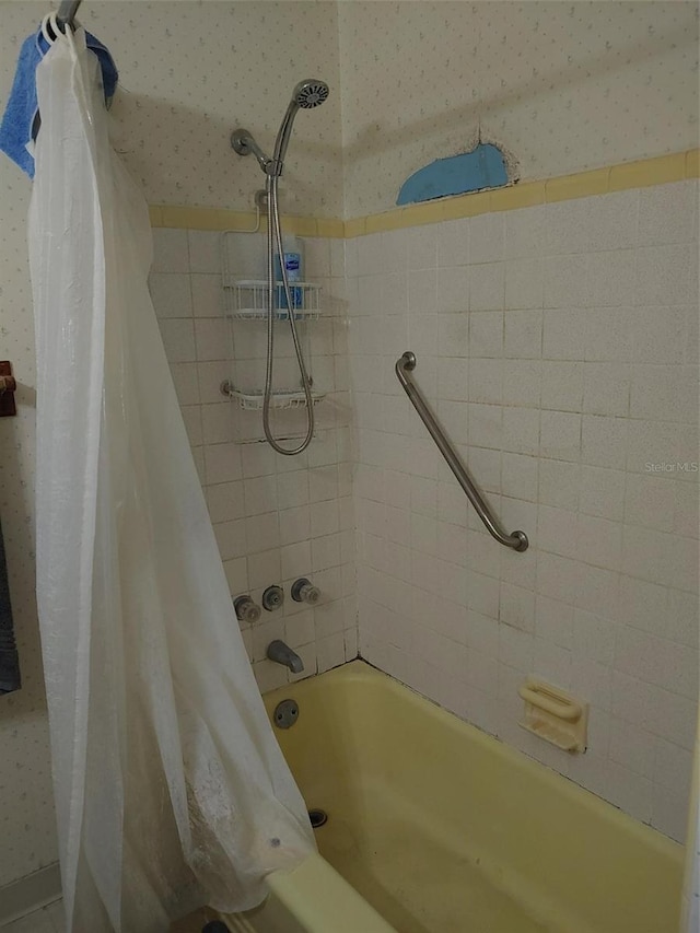 full bathroom with wallpapered walls and shower / tub combo