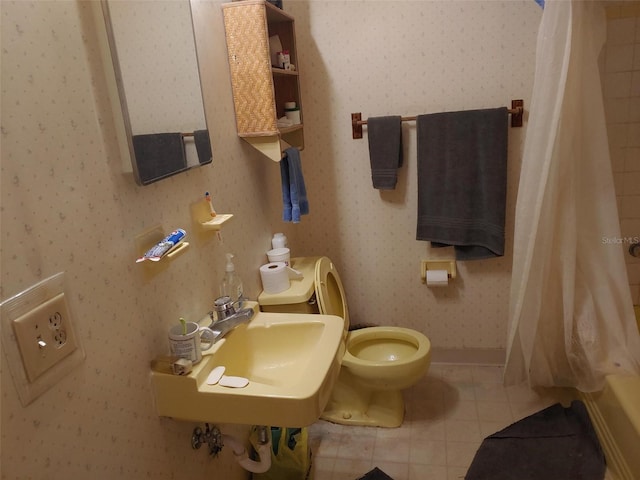 bathroom with toilet, a sink, a shower with shower curtain, wallpapered walls, and tile patterned flooring