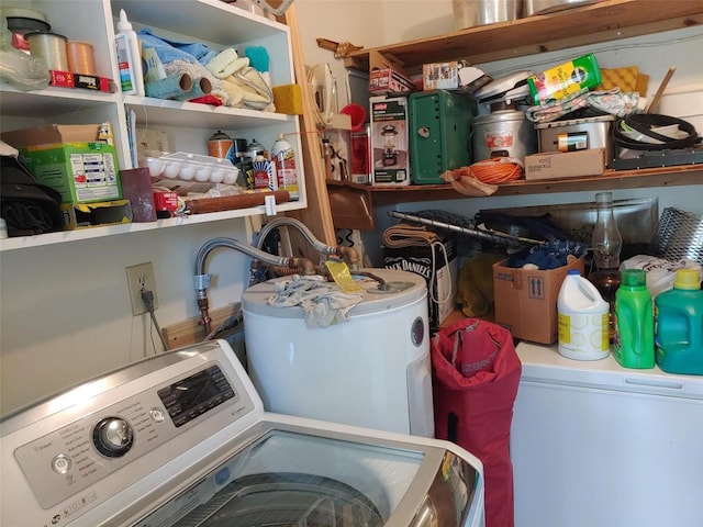 clothes washing area with washer / clothes dryer, laundry area, and water heater