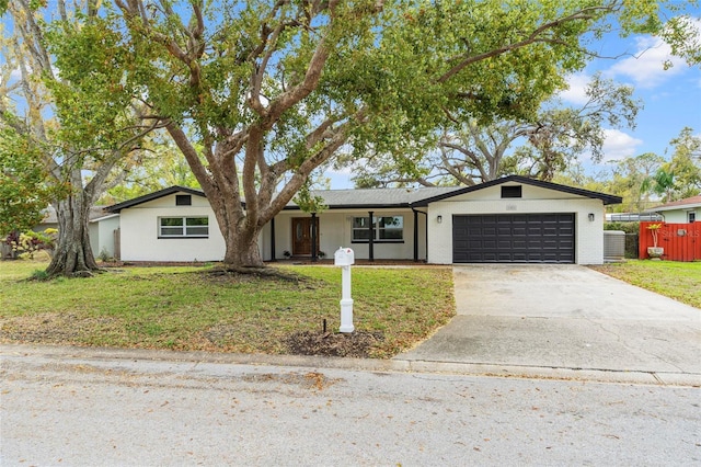 view of front of home with brick siding, a front lawn, fence, concrete driveway, and a garage