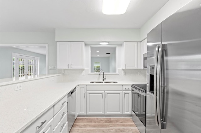 kitchen with light countertops, plenty of natural light, appliances with stainless steel finishes, and a sink