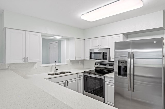 kitchen with white cabinets, appliances with stainless steel finishes, and a sink