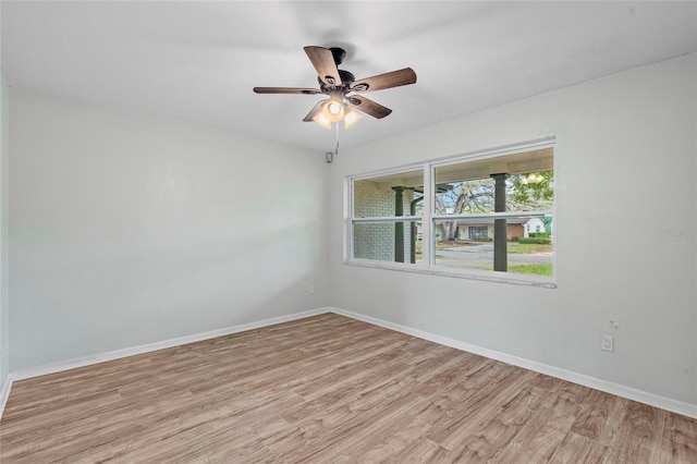 empty room with baseboards, a ceiling fan, and light wood finished floors