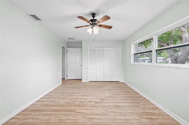 unfurnished bedroom featuring visible vents, a ceiling fan, a closet, light wood finished floors, and baseboards