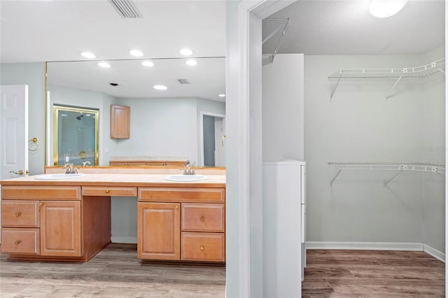 bathroom featuring visible vents, wood finished floors, and a sink