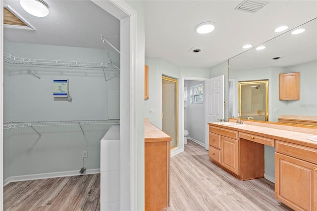 full bath with a shower stall, toilet, wood finished floors, and visible vents