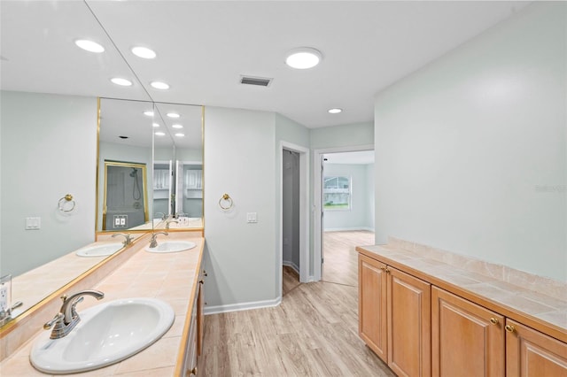 bathroom with visible vents, wood finished floors, and a sink