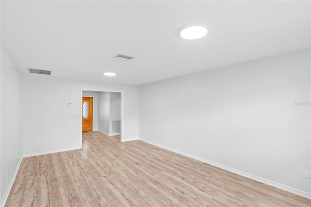 unfurnished room featuring visible vents, baseboards, and light wood finished floors