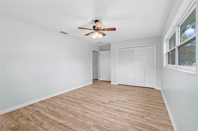 unfurnished bedroom featuring light wood-type flooring, visible vents, baseboards, and a ceiling fan