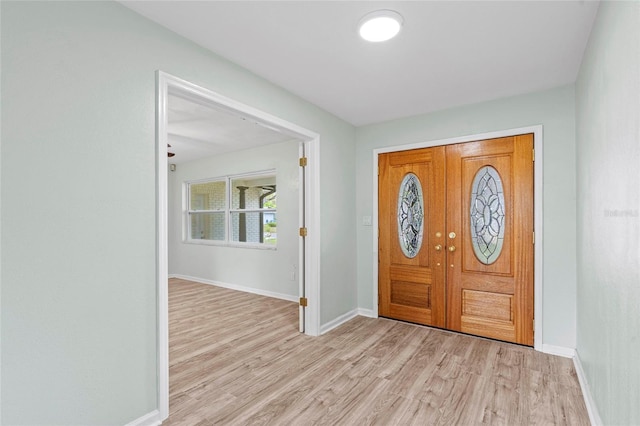 foyer entrance featuring baseboards and light wood finished floors