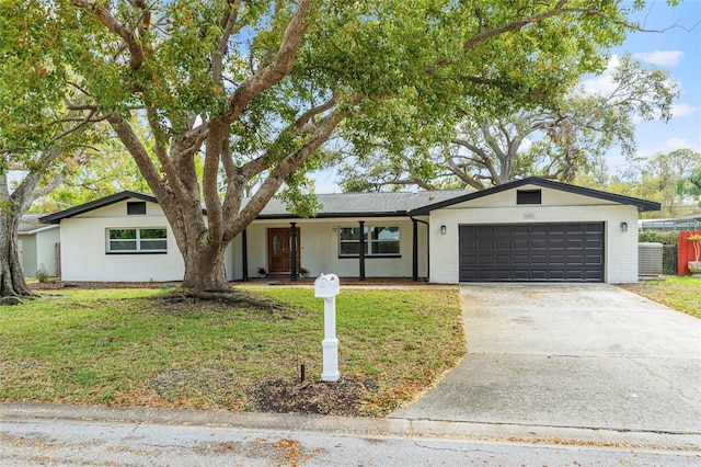 view of front of house featuring brick siding, concrete driveway, and a front lawn