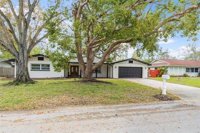 view of front of property with a front yard, fence, a garage, and driveway