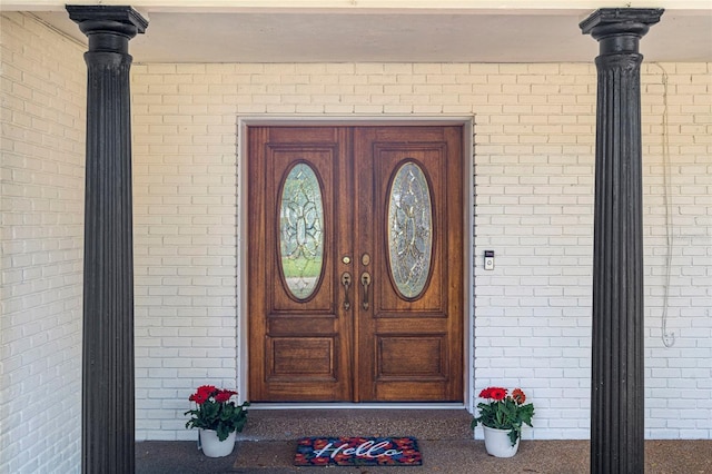 view of exterior entry featuring brick siding