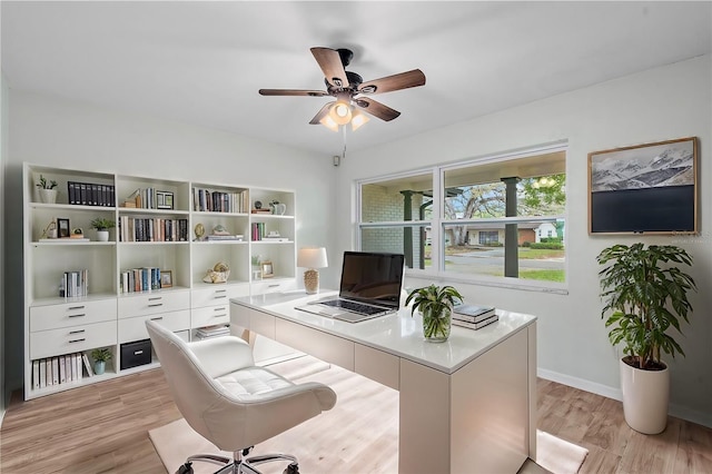 home office featuring light wood-style flooring, baseboards, and a ceiling fan