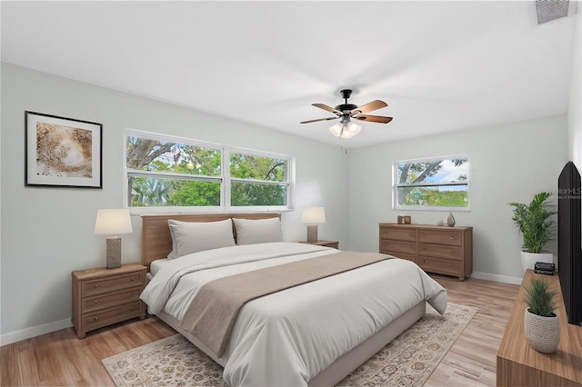 bedroom with light wood-style flooring, multiple windows, and visible vents