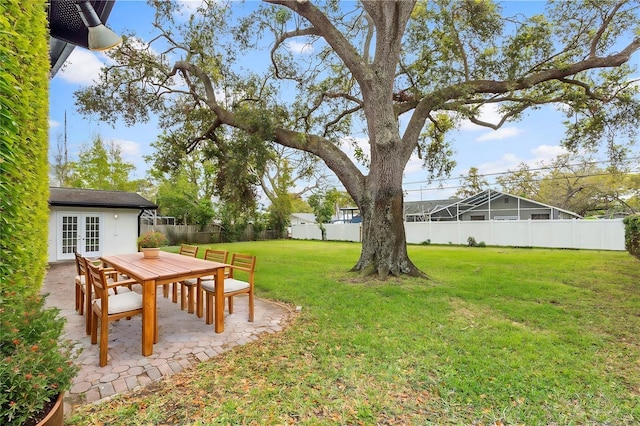 view of yard featuring french doors, a fenced backyard, and a patio area