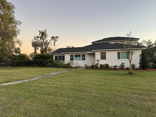 view of front of property with stucco siding and a lawn