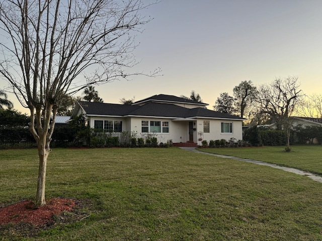 ranch-style home featuring stucco siding and a front yard