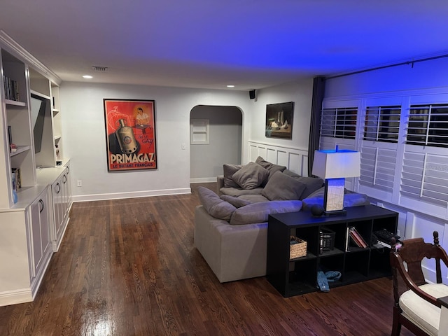 living room featuring recessed lighting, visible vents, arched walkways, and dark wood-type flooring