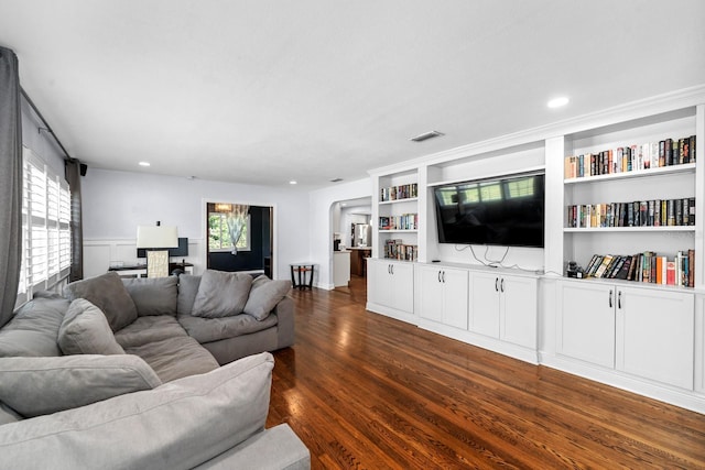 living room featuring built in shelves, a healthy amount of sunlight, recessed lighting, and dark wood-style flooring