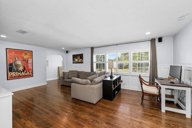 living area with recessed lighting, a wainscoted wall, arched walkways, visible vents, and wood finished floors
